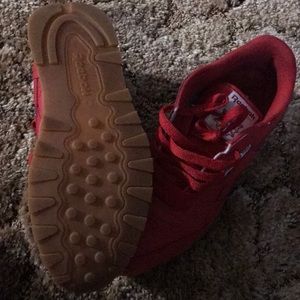 Red and white reeboks with the gum bottoms